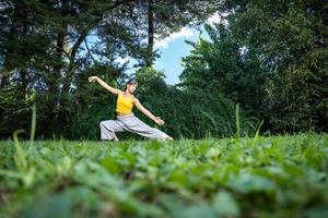 mujer practicando qi gong Tai chí ángulo a suelo nivel, selectivo enfocar. foto