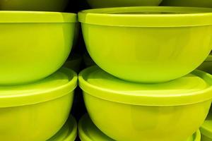 Green plastic bowls made from recyclable materials. Sale of eco-friendly kitchenware. photo