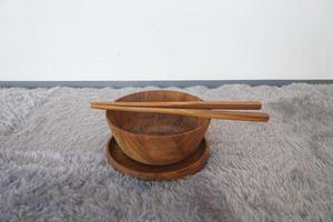 set of wooden tableware on gray background. Wooden bowl, chopsticks, eco friendly concept. Top up view photo