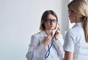 Professional doctor woman with stethoscope and heartbeat health patient light background photo