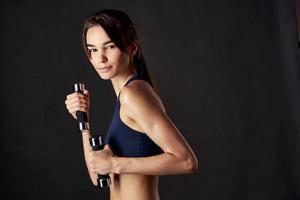 sportive woman holding dumbbells in hands fitness gym exercise photo