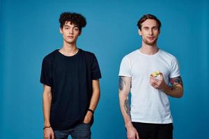 two men in t-shirts on a blue background and pants chatting friends photo