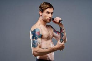 tattooed guy naked torso muscled dumbbells fitness sport photo