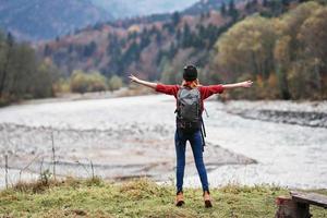 mujer caminante con mochila cerca río montañas paisaje libertad foto