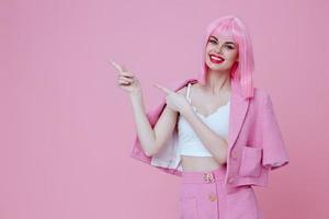 positivo joven mujer en un rosado traje gesticulando con su manos emociones divertido rosado antecedentes inalterado foto