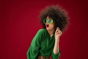 Beauty Fashion woman green dress afro hairstyle dark glasses twenty percent in hands studio model unaltered photo