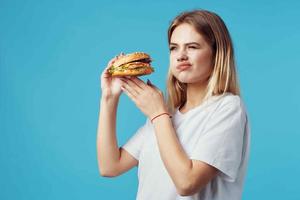 rubia en blanco camiseta hamburguesa rápido comida bocadillo alegría foto