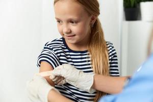 the doctor seals the child's hand with a plaster treatment photo