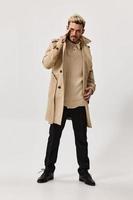 male model posing on a light background in fashionable clothes coat model pants photo