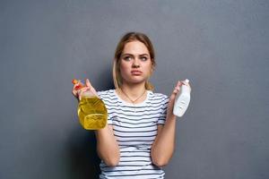 Cleaning lady holding detergent in hands cropped view of service gray background photo