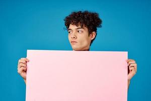 guy with curly hair holding pink Poster mockup photo