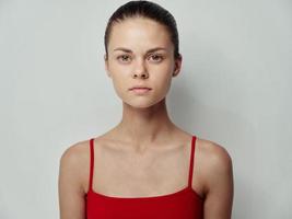 joven mujer limpiar piel cosmetología rojo camiseta ligero antecedentes modelo foto