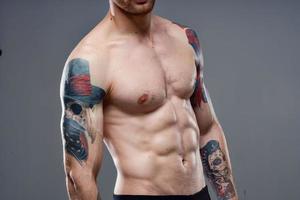 man with pumped up press tattoo on his arms cropped view of workout photo