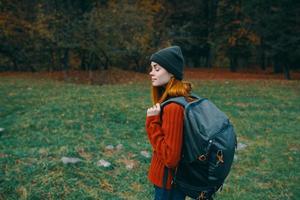 woman red sweater backpack green grass landscape model travel tourism photo