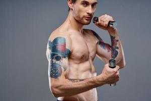 tattooed guy naked torso muscled dumbbells fitness sport photo