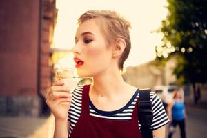 bonito mujer al aire libre comiendo hielo crema caminar foto