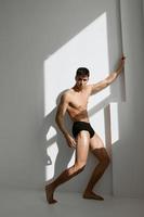 attractive man with naked body in black panties posing photo