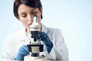 woman looking through a microscope laboratory research science experiment photo