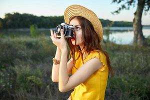 mujer fotógrafo mira dentro el cámara lente naturaleza verano Fresco aire foto
