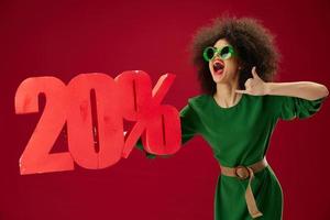 Portrait of a charming lady curly hairstyles green dress twenty percent discount red background unaltered photo