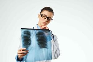 female medical professional in a white coat looking at an x-ray to a professional photo