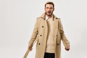 man with surprised expression beige coat autumn style side look photo