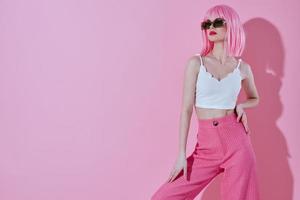 Positive young woman attractive look pink wig stylish clothes color background unaltered photo