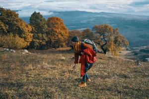 woman hiker with backpack travel autumn trees mountains landscape photo
