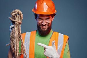 Emotional man in work uniform orange helmet rope professional photo