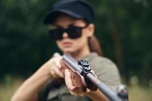 Woman Shotgun in hand, sight, target hunting green leaves photo