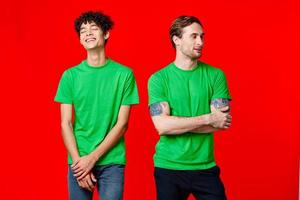 two men in green t-shirts are standing next to friendship photo