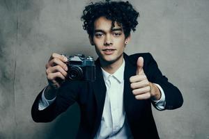 handsome guy in a suit with a camera lessons curly hair emotions model photo