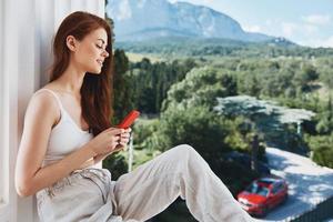 pretty woman with a red phone Terrace outdoor luxury landscape leisure Lifestyle photo