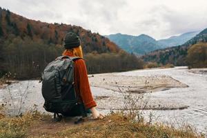 mujer en otoño en el montañas con un mochila en su espalda viaje turismo río modelo foto