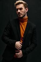 guy model in an orange sweater blonde jacket the dark background cropped view photo