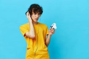 guy plays with joystick in yellow t-shirts isolated backgrounds photo