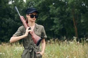 Woman on outdoor Hunting walk with weapons in dark glasses weapons photo