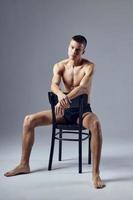 sporty man sitting with his elbows on the back of a chair attractive look photo