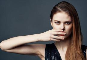 Portrait of a beautiful woman gesturing with her hands gray background cropped view close-up photo