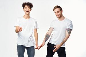 dos gracioso amigos en blanco camisetas riendo positivo emociones foto