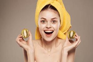 cheerful woman with a towel on her head and hands skin care naked shoulders beige background photo