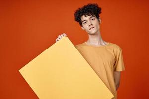 emotional guy with curly hair island in hands advertising red background photo