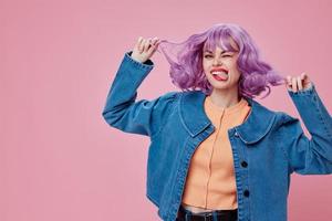 positivo joven mujer en mezclilla chaqueta púrpura pelo glamour maquillaje estudio modelo inalterado foto