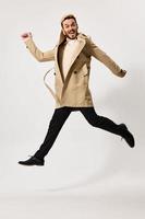 man in beige coat jump emotions isolated background photo