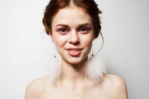 woman with bare shoulders bright makeup jewelry earrings close-up photo