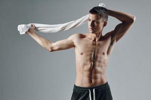sporty man muscular press towels behind head posing isolated background photo