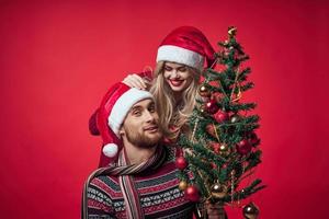 Cheerful young couple New Year in a place of Christmas holiday photo