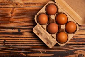 huevos de gallina frescos en cajas de cartón sobre fondo de madera foto