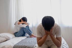 The husband is unhappy and disappointed in the erectile dysfunction during sex while his wife sleeping on the bed. Sexual Problems in Men, The concept of erectile dysfunction according. photo