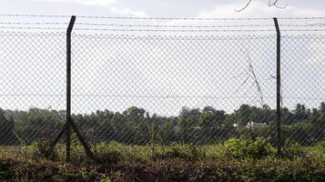 A high fence of empty field used for security reason no trespassing, good for backdrop or background. photo